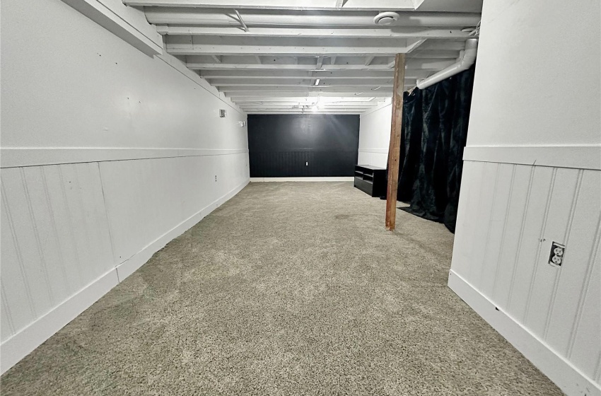 Basement rec space or windowless sleep area. Utility room is behind the curtain