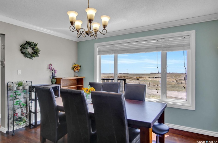 Dining room featuring plenty of natural light, crown molding, dark hardwood / wood-style floors, and an inviting chandelier