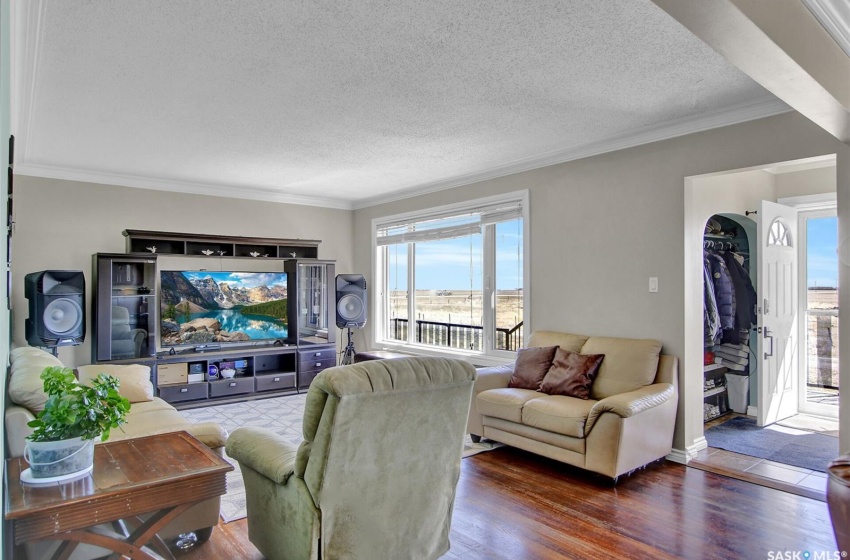 Living room with crown molding, a textured ceiling, and hardwood / wood-style floors