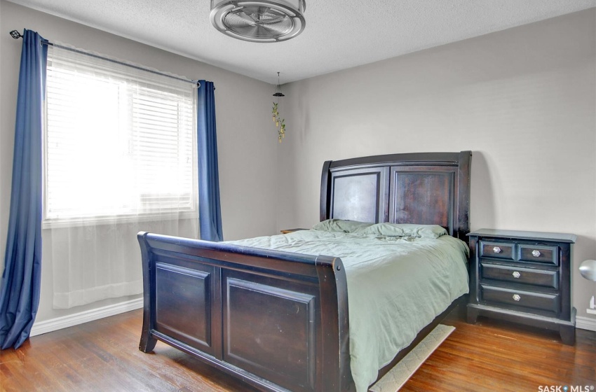 Bedroom featuring a textured ceiling, dark hardwood / wood-style flooring, and multiple windows