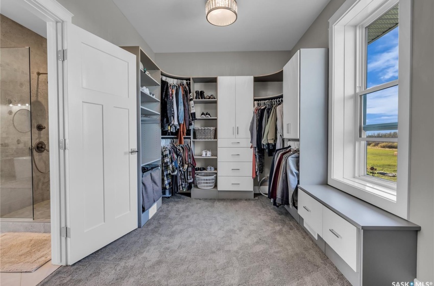 Walk in Closet with detailed organization system. More cabinets on reverse side of photo.