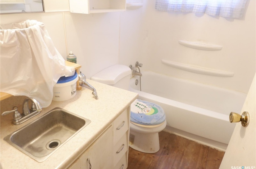 Full bathroom featuring shower / tub combination, wood-type flooring, toilet, and vanity with extensive cabinet space