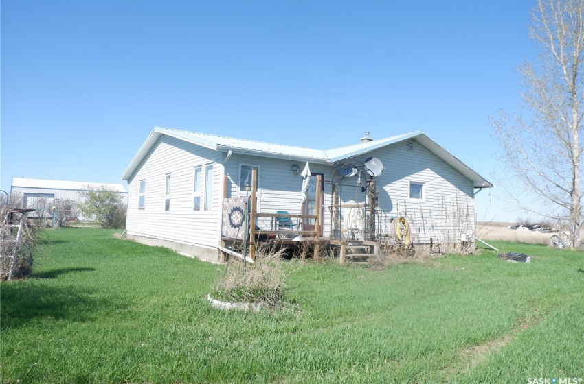 Back of property with a deck and a lawn