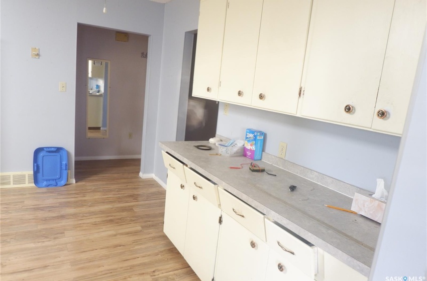 Kitchen with white cabinetry and light hardwood / wood-style flooring