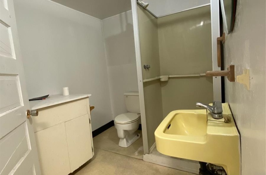 Bathroom featuring sink, concrete floors, toilet, and a drop ceiling