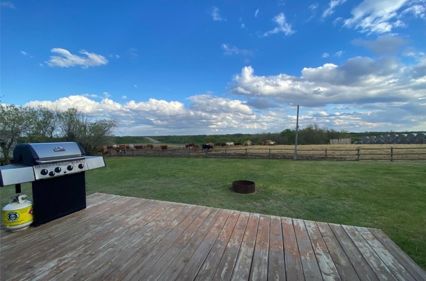 Wooden terrace featuring area for grilling, a rural view, and a lawn