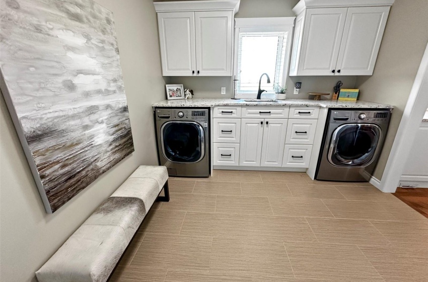 The laundry/mudroom off the kitchen has ample cabinetry and leads to the triple attached heated garage.