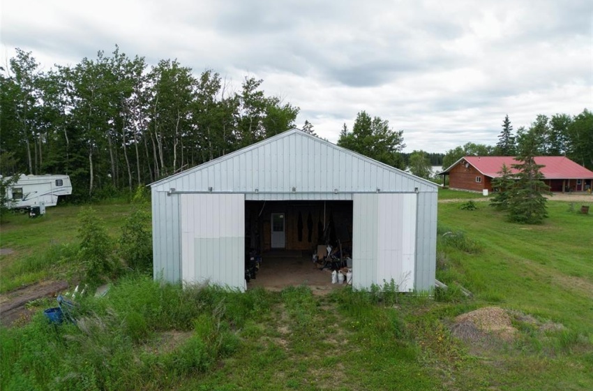 View of outbuilding featuring a lawn