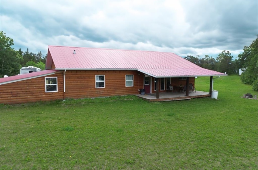 Back of house with a deck and a yard