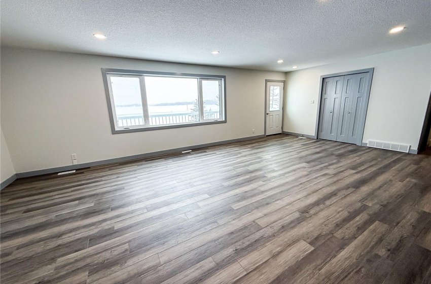 Unfurnished bedroom featuring dark hardwood / wood-style floors, a textured ceiling, and a closet