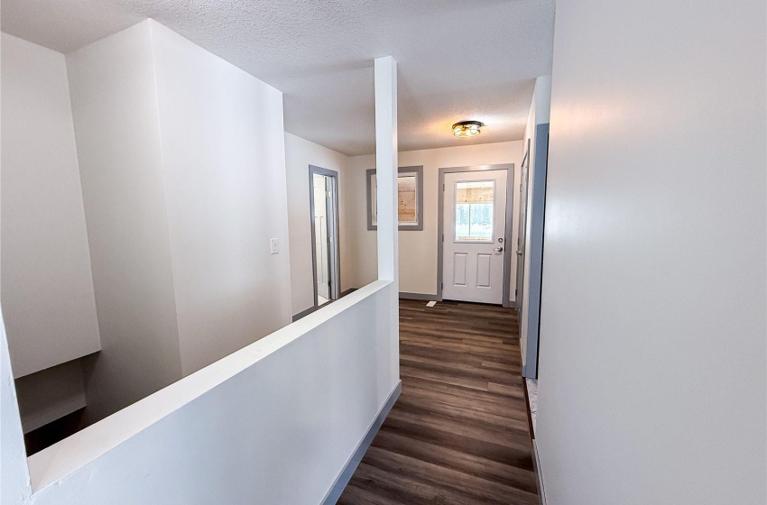 Corridor featuring a textured ceiling and dark wood-type flooring