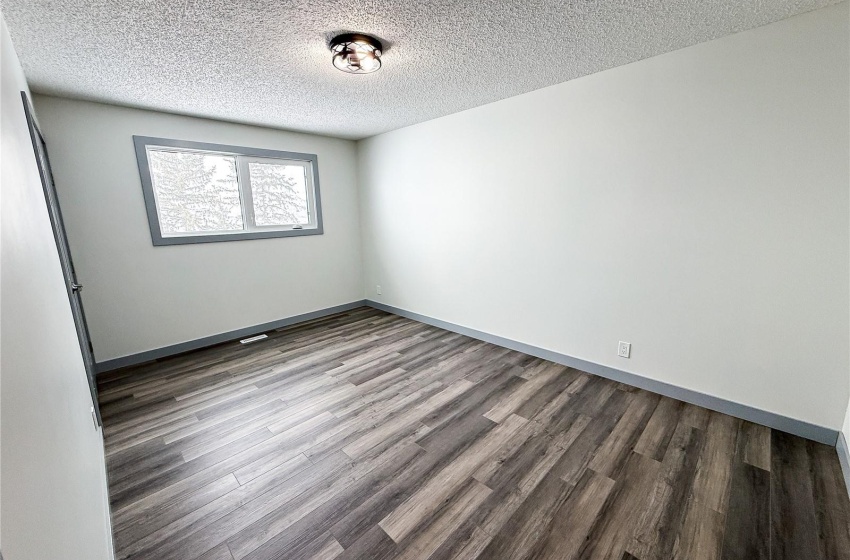 Spare room featuring dark hardwood / wood-style flooring and a textured ceiling