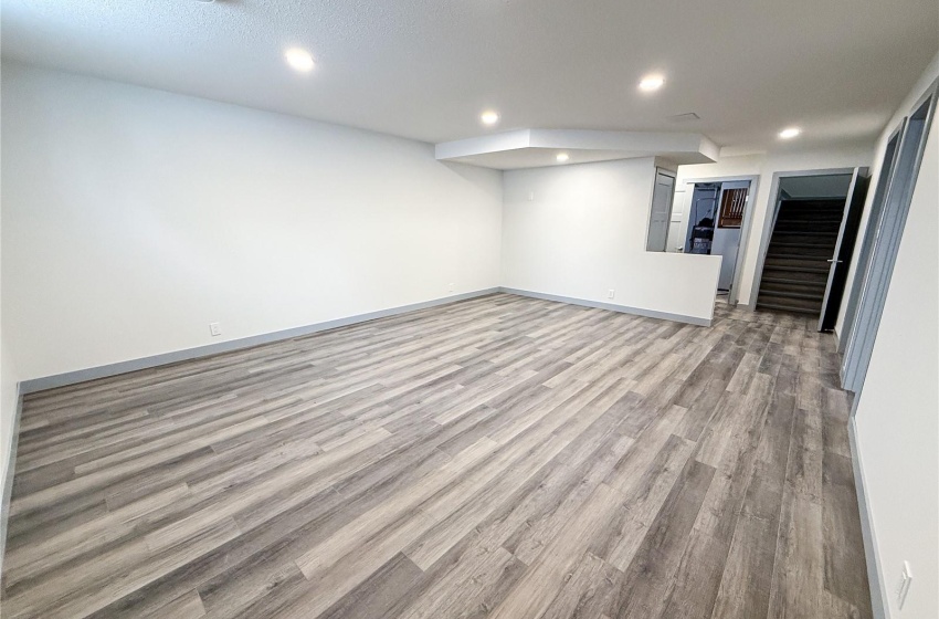 Basement featuring a textured ceiling and light wood-type flooring