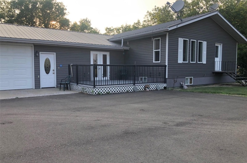 View of front of house with a deck and a garage