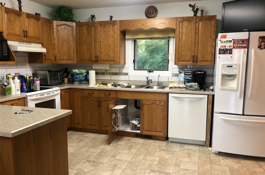 Kitchen featuring light tile patterned flooring, sink, white appliances, and backsplash