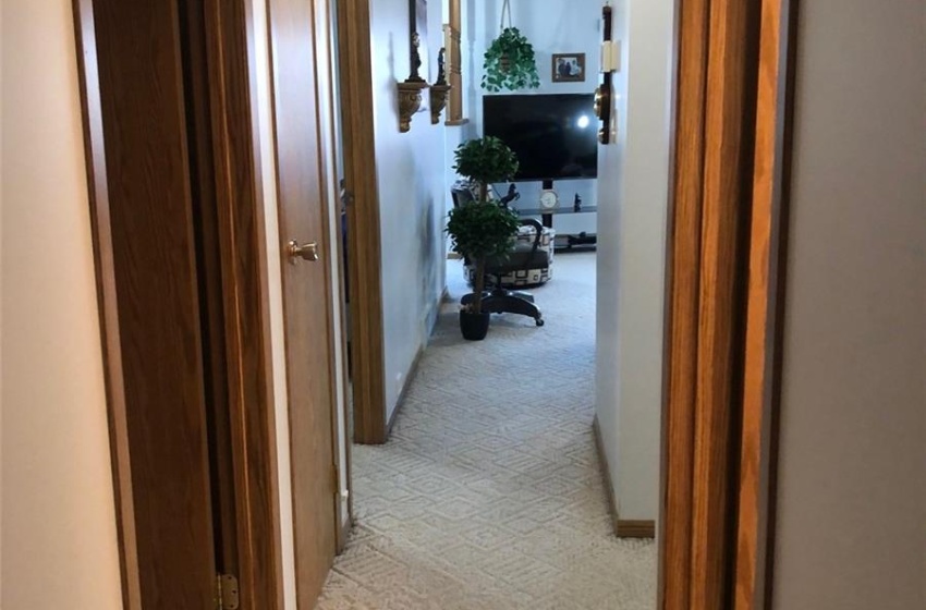 Hallway featuring light carpet and a textured ceiling