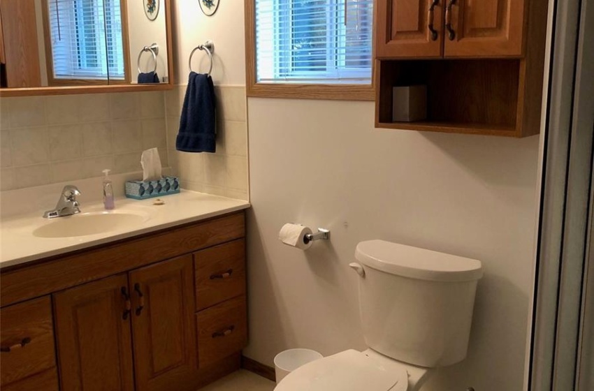 Bathroom featuring vanity, toilet, decorative backsplash, and tile patterned flooring