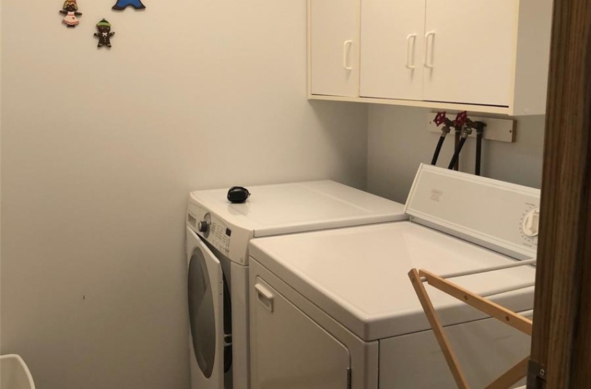 Laundry room featuring independent washer and dryer and cabinets