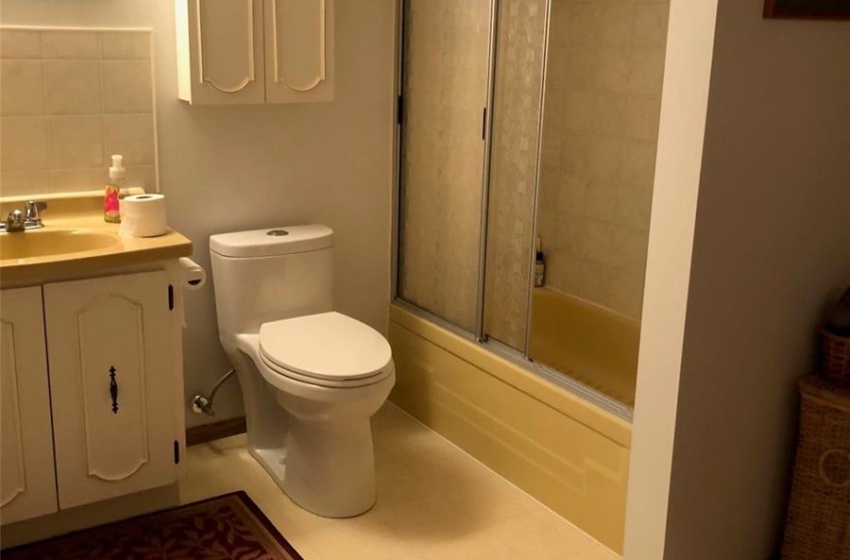 Full bathroom with vanity, toilet, tile patterned floors, and combined bath / shower with glass door