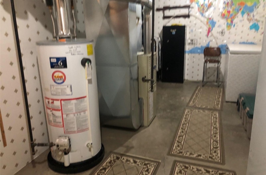 Utility room featuring water heater and heating unit