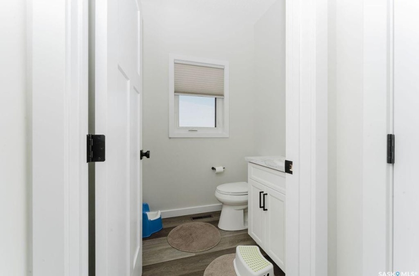 Bathroom featuring vanity, hardwood / wood-style flooring, and toilet