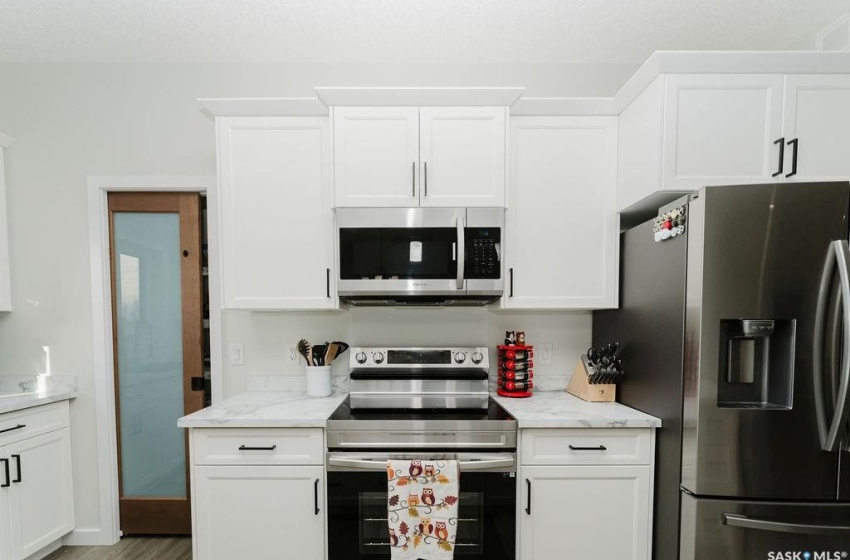 Kitchen featuring appliances with stainless steel finishes and white cabinetry