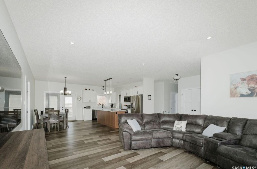 Living room featuring dark wood-type flooring, a notable chandelier, and sink