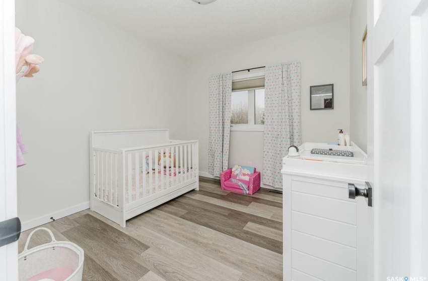 Bedroom featuring a nursery area and light hardwood / wood-style flooring