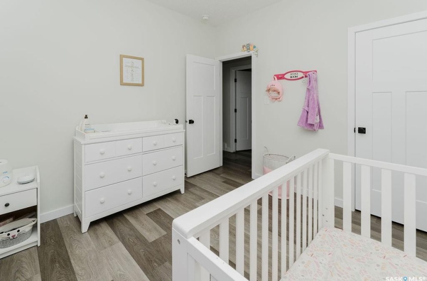 Bedroom featuring light hardwood / wood-style flooring and a crib