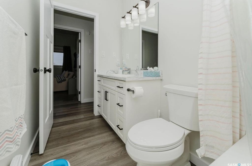 Bathroom featuring vanity, hardwood / wood-style floors, and toilet