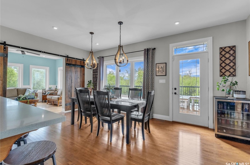 Dining area with a barn door, hardwood floors, and a chandelier