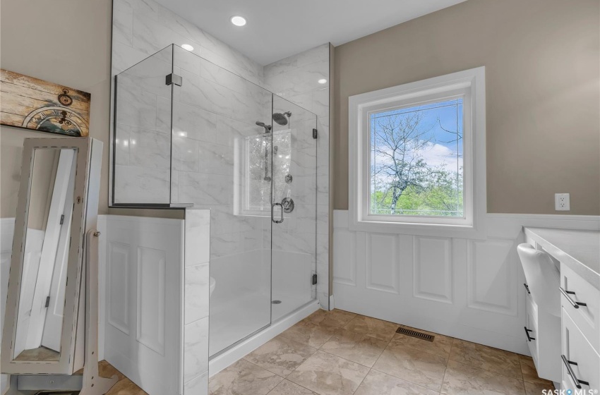 Bathroom with tile flooring, an enclosed shower, and vanity