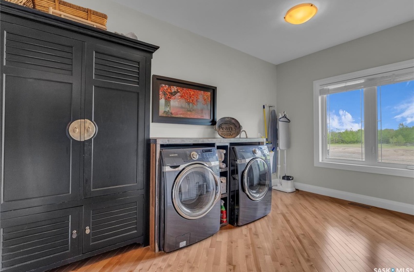 Laundry area featuring hardwood floors and washing machine and dryer