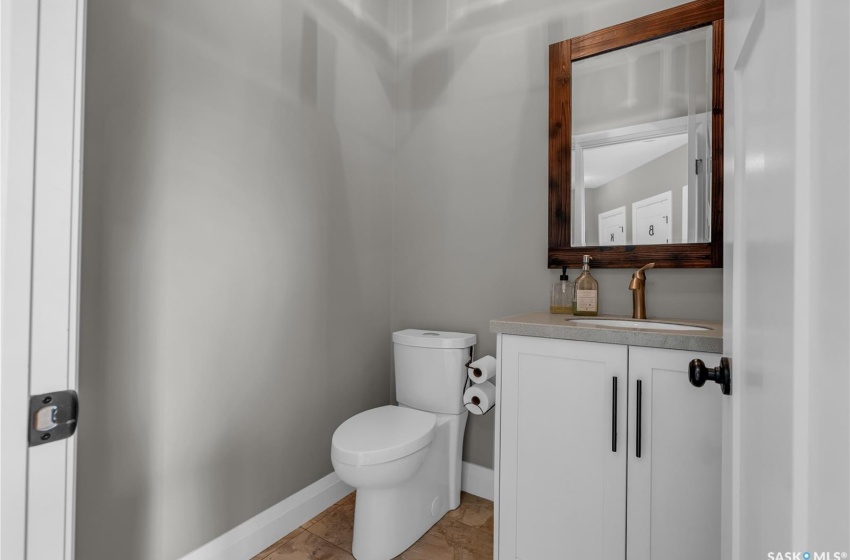 Mudroom bathroom featuring tile flooring, vanity, and toilet