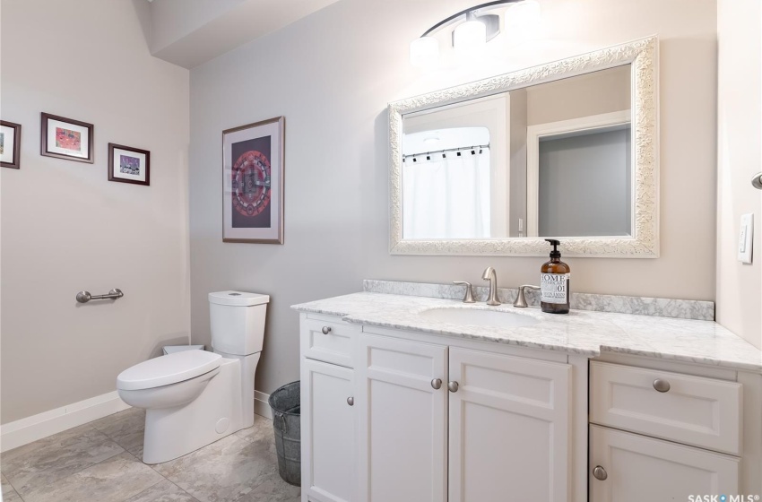 Bathroom with tile flooring, vanity, and toilet