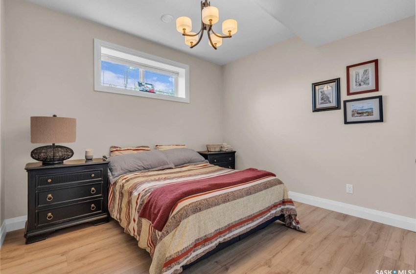 Bedroom featuring a chandelier and laminate plank flooring