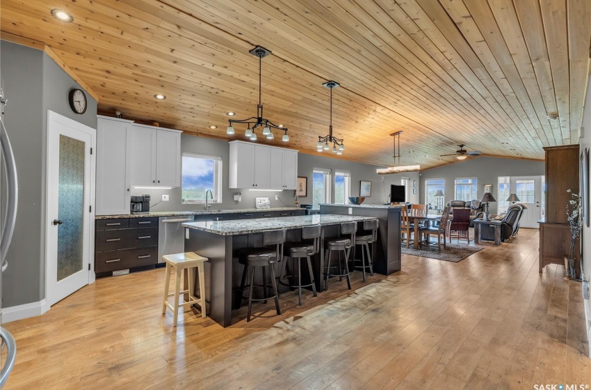 Kitchen featuring a center island, a breakfast bar, white cabinets, and wooden ceiling