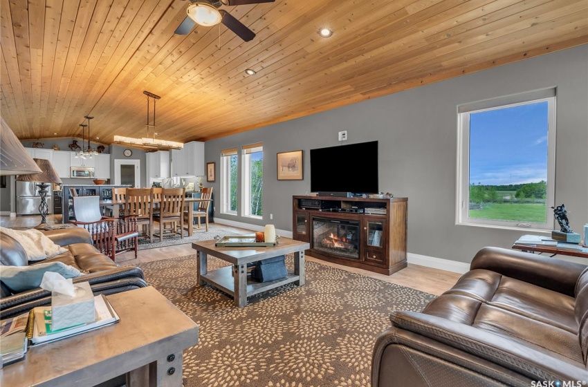 Living room with ceiling fan, vaulted ceiling, and wooden ceiling