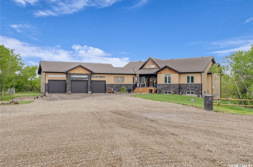 View of front of property featuring a front lawn and a triple car garage