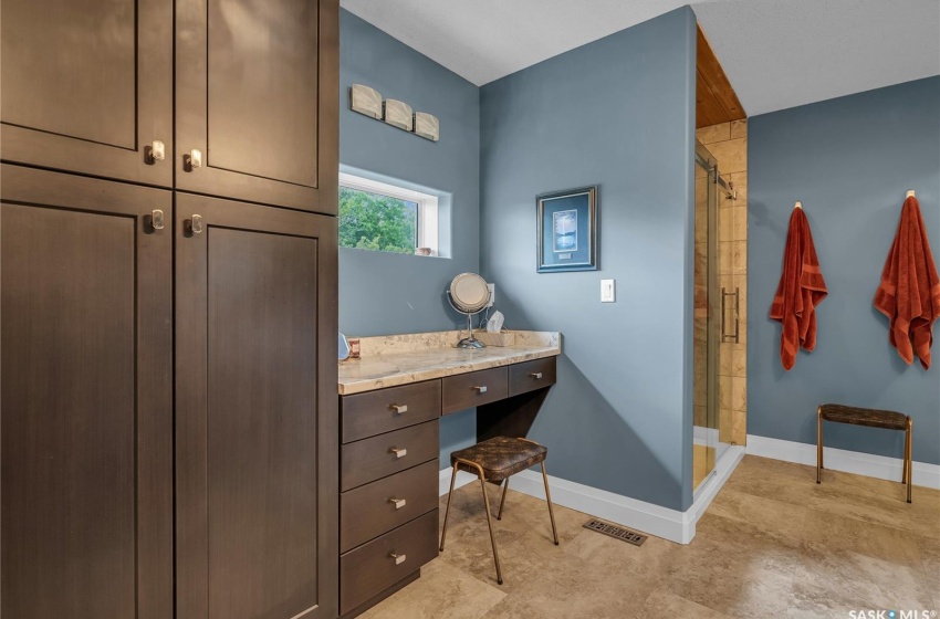 Bathroom with an enclosed shower, tile flooring, and vanity