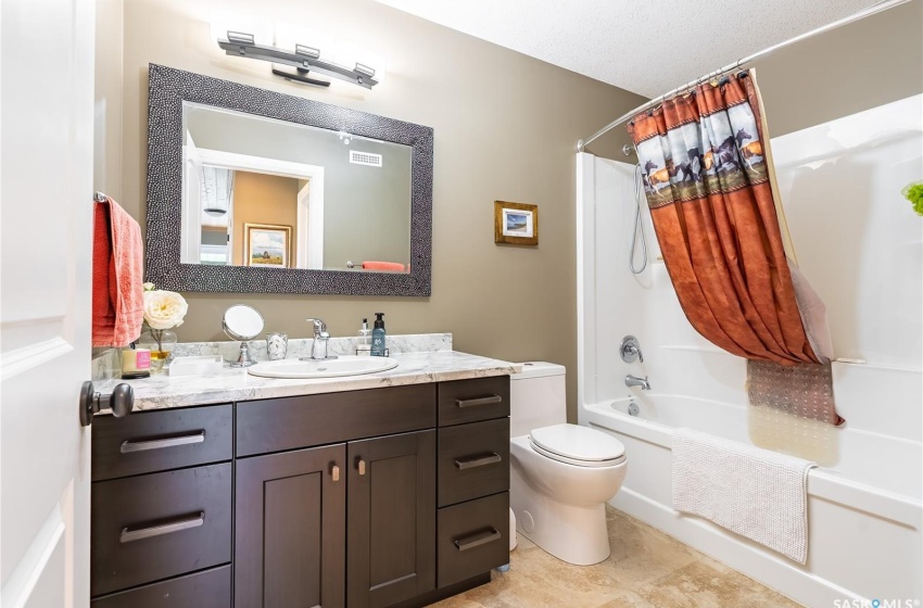 Full bathroom featuring shower / tub combo, vanity, and toilet