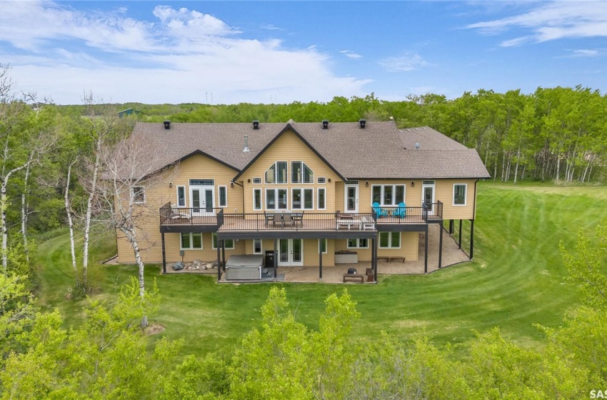 Back of property with a yard, a deck, and a patio