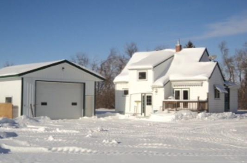 View of front of home featuring a garage and an outdoor structure