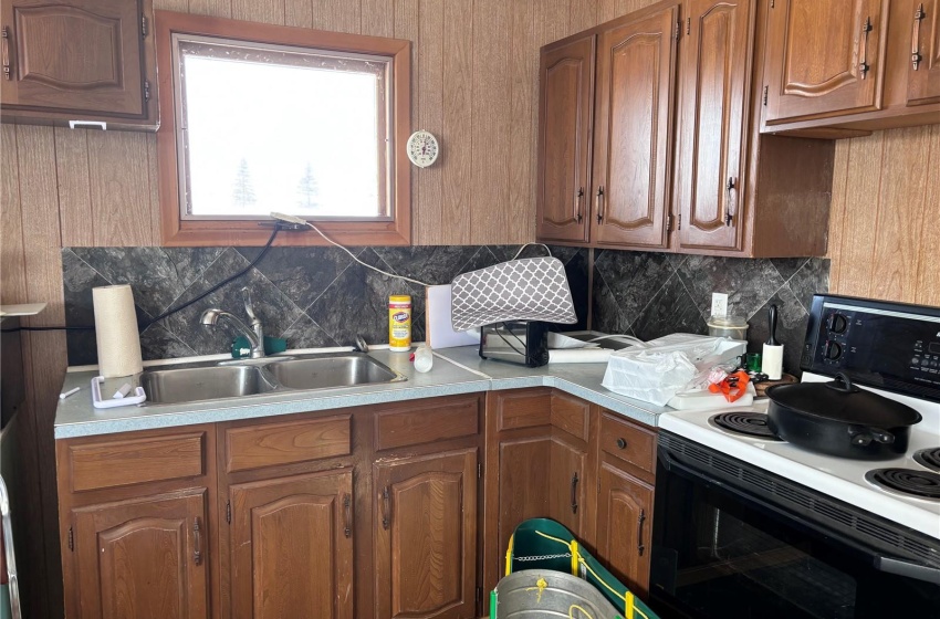 Kitchen with tasteful backsplash, electric stove, and sink