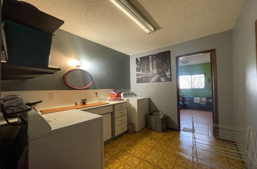 Bathroom with washer and clothes dryer and a textured ceiling