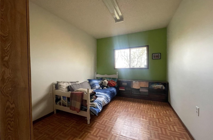 Bedroom featuring a textured ceiling and light parquet flooring