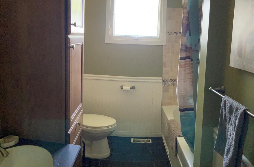 Full bathroom with tile flooring, shower / bath combination with curtain, vanity, and toilet