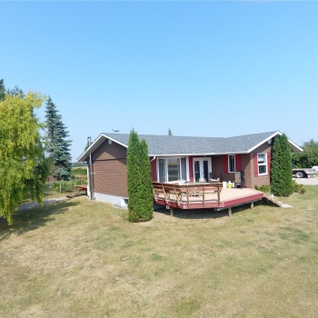 View of front of house with a front yard and a wooden deck