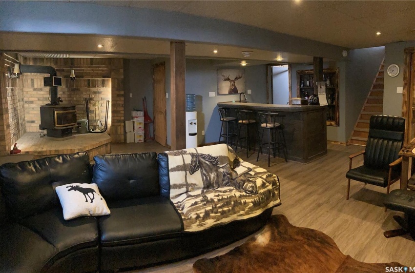 Living room featuring bar, a wood stove, and light hardwood / wood-style flooring