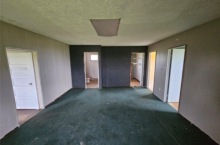 Unfurnished bedroom with ensuite bathroom and a textured ceiling